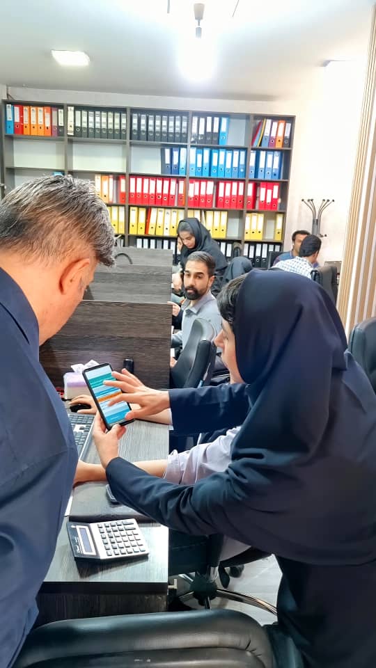 A group of people in an officeDescription automatically generated